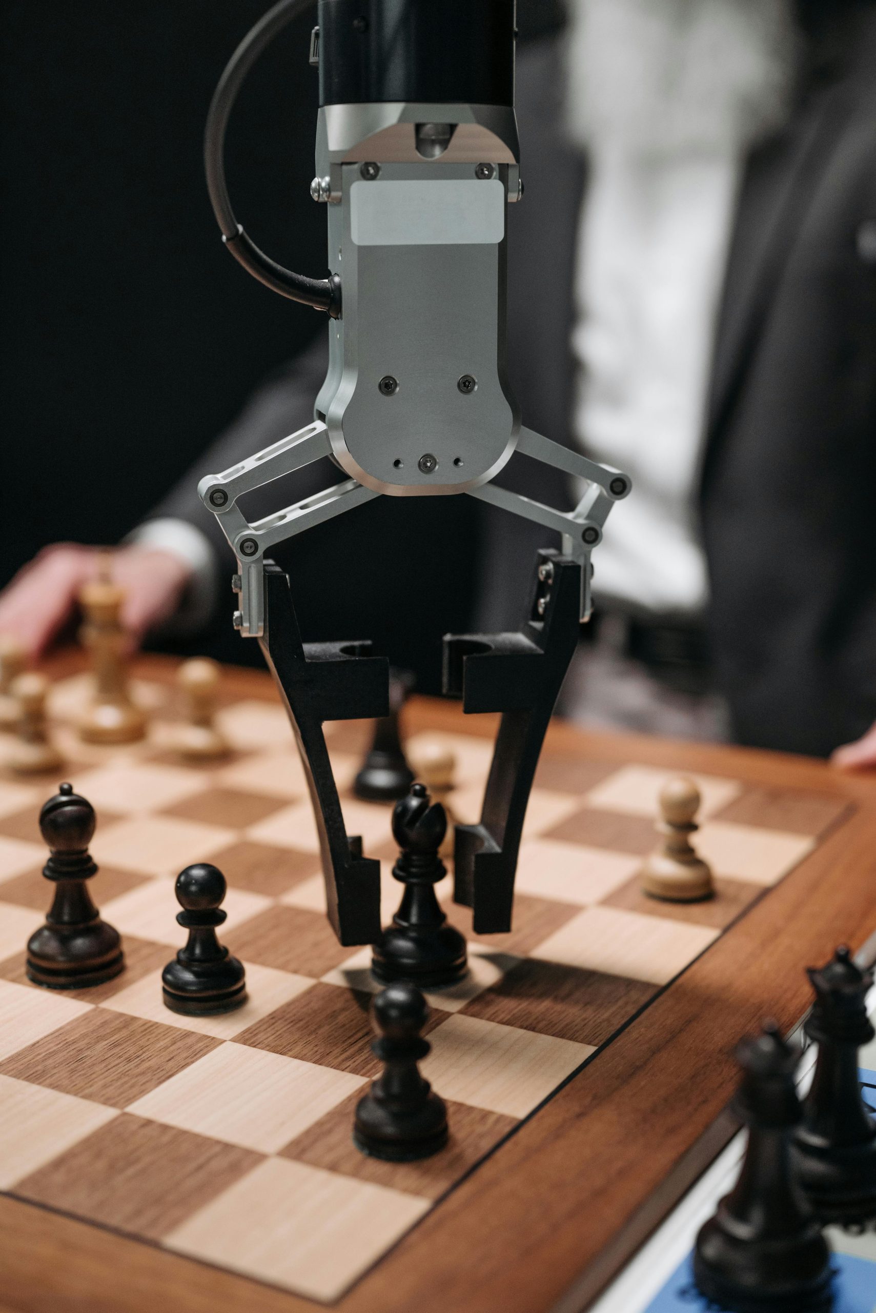 Home Futuristic AI robot arm making chess move during a game with a human player.